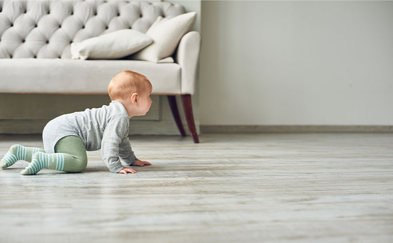 baby crawling on wood look flooring in living room